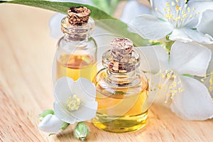 Essential oil in glass bottle with fresh jasmine flowers, beauty treatment. Spa concept Selective focus. Fragrant oil of jasmine f