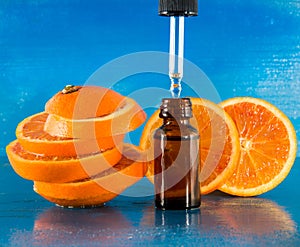 Essential oil with orange slices, bottle and dropper