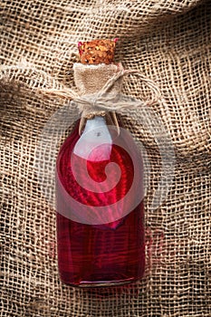 essential oil of red beet on the background of burlap top view photo