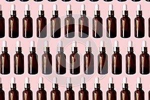 Essential oil serum glass bottle pattern isolated on pink background. Natural Serums. Cosmetic concept photo