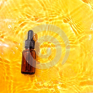 Essential oil in water on a yellow background. The concept of aromatherapy. The preservation of the health, natural cures.