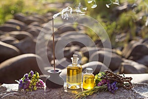 Essential Oils and Aromatic sticks for meditation on a rock