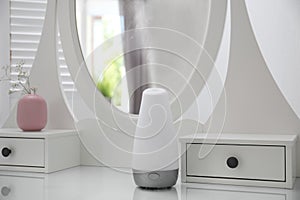 Essential oils diffuser on white    in room. Space for text