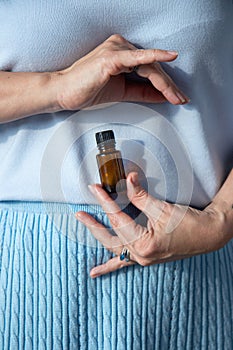 Essential oils glass bottle in the hand of a woman