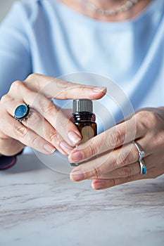 Essential oils glass bottle in the hand of a woman