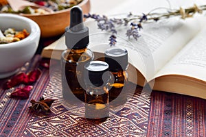 Essential oils with herbs and book photo