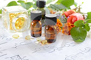 Essential oils with herbs and supplement on science sheet