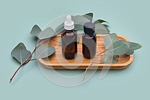 Essential oils with natural eucalyptus leaves on mint pastel background. Beauty products, facial skin care, spa beauty treatment