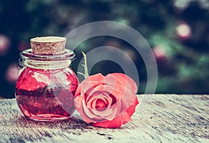 Essential rose oil in a glass bottle. Love elixir. Love potion. photo