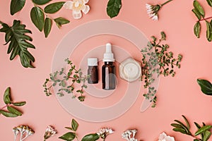 essential serum or skincare product with natural green leaves and flowers on a beauty background