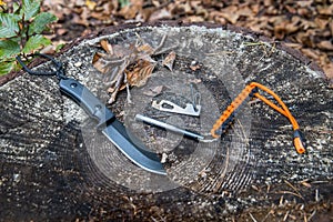 Essential tactical bushcraft tools on a tree stump