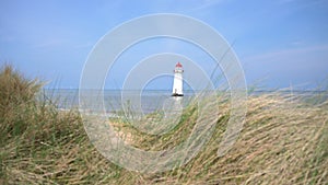 Establishing shot of the Point of Ayr lighthouse, Talacre, Wales at high tide