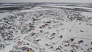 Establishing shot on a village covered with snow in the Russian Arctic. Aerial view of the winter landscape of a village