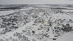 Establishing shot on a village covered with snow in the Russian Arctic. Aerial view of the winter landscape of a village