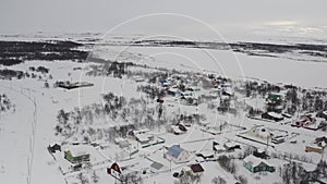 Establishing shot on a village covered with snow in the Russian Arctic. Aerial view of the winter landscape of a village