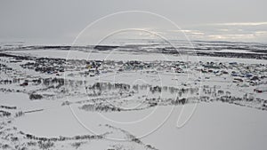 Establishing shot on a village covered with snow in the Russian Arctic. Aerial view of the winter landscape of a village