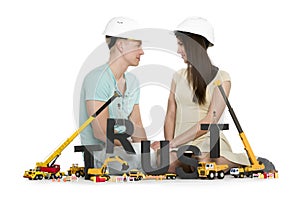 Establishing trust: Young couple with machines building trust-word.