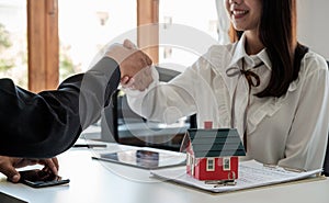 Estate agent and customer shaking hands after fafter signing contract about home insurance and investment loan.