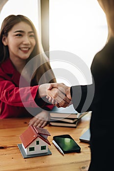 Estate agent and customer shaking hands after finished contract after about home insurance and investment loan