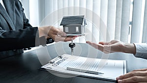 Estate agent giving house and keys to client after signing agreement contract real estate with approved mortgage application form