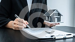 Estate agent giving house and keys to client after signing agreement contract real estate with approved mortgage application form