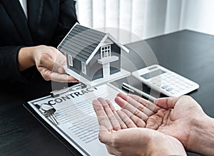 Estate agent giving house and keys to client after signing agreement contract real estate with approved mortgage application form