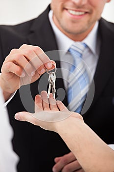Estate agent giving house keys to man