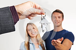 Estate Agent Handing Over House Keys To Young Couple