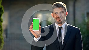 Estate agent holding smartphone with green screen, app for housing rental