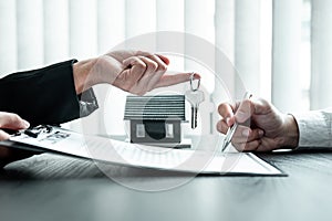 Estate agent are presenting home loan and sending keys to client after signing contract to rental house Insurance with approved