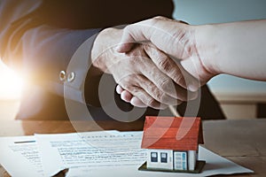 Estate agent shaking hands with his customer after contract sign