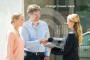 Estate Agent Shaking Hands With Young Couple