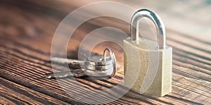 Estate concept with symbol of security, lock padlock with key on old wooden background.