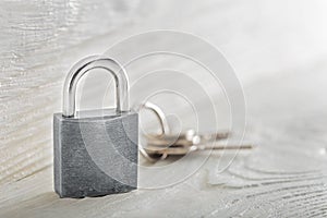 Estate concept with symbol of security, lock padlock with key on wooden background.