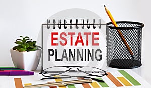 Estate Planning word with Notepad on white background with markers ,charts and glasses