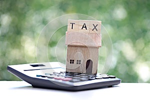 Estate tax,Model house and calculator on natural green background,Business investment and Property tax concept
