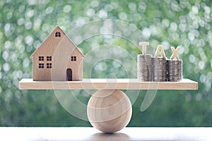 Estate tax,Model house with stack of coins money and tax word on seesaw green background,Business investment and Property tax