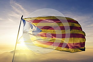Estelada Catalonia catalan republic state independence movement flag textile cloth fabric waving on the top sunrise mist fog