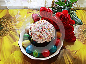 Ester cake and Easter eggs around with beautiful bouquet of red roses