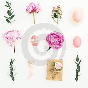 Ester holiday composition with eggs, pink peonies, hypericum and eucalyptus on white background. Flat lay