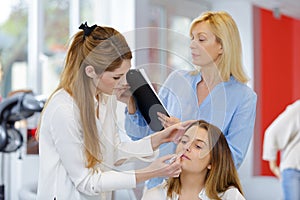 esthetician applying makeup in stylish beauty studio