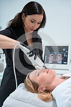 Esthetician performs a hardware procedure for rejuvenating the frontal zone