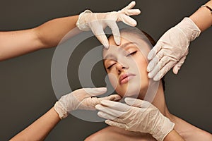 estheticians in medical gloves examining face