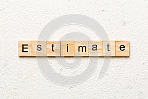 estimate word written on wood block. estimate text on table, concept