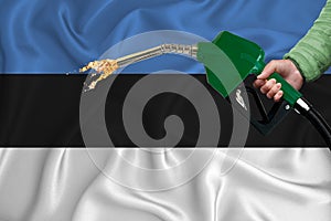 ESTONIA flag Close-up shot on waving background texture with Fuel pump nozzle in hand. The concept of design solutions. 3d