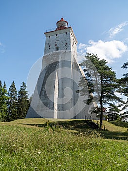 Estonia, Hiiumaa Island. View of the old massive masonry lighthouse statically rises above the tops of the trees