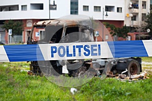 Estonian police tape in front of a burnt truck