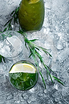 Estragon lemonade. Concept refreshing summer drinks. Fresh cool lemonade tarragon with ice and citrus slices.