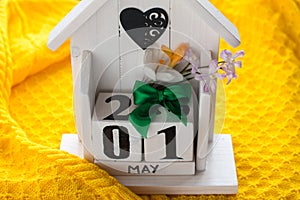 An eternal calendar in the form of a house on a spring yellow background.