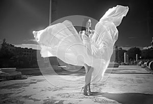 Ethereal, divine bride with flying, shiny dress standing in temp